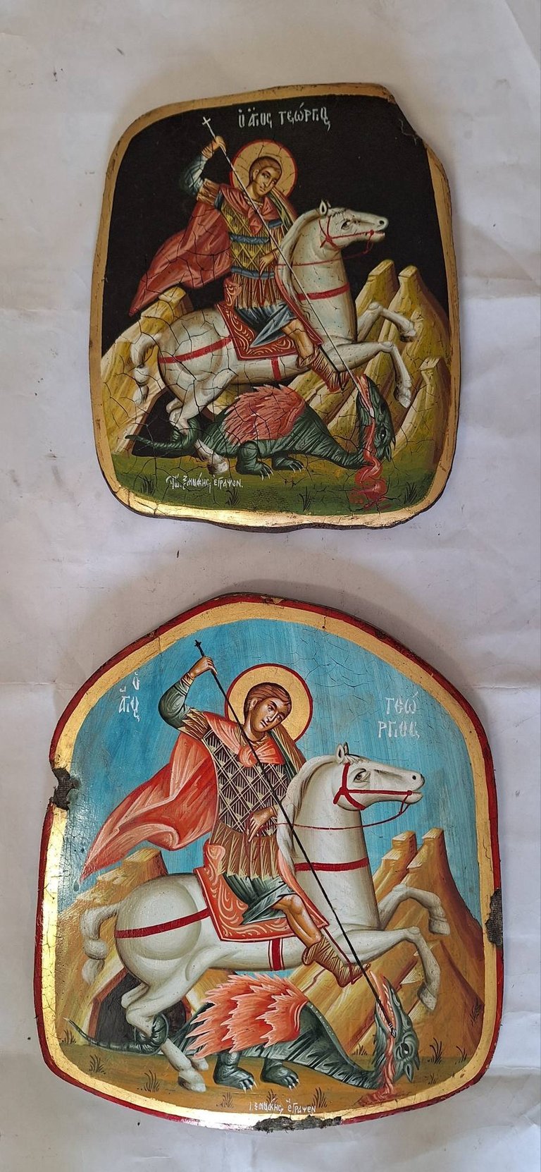 Two Orthodox religious icons depicting Saint George on horseback slaying a dragon, with Cyrillic text and gold-trimmed wooden panels