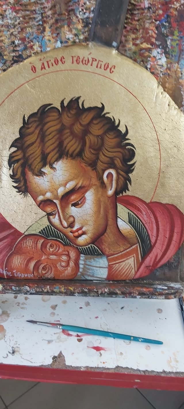 Orthodox religious icon of a young saint with brown hair and gold halo, painted in traditional style with red garment