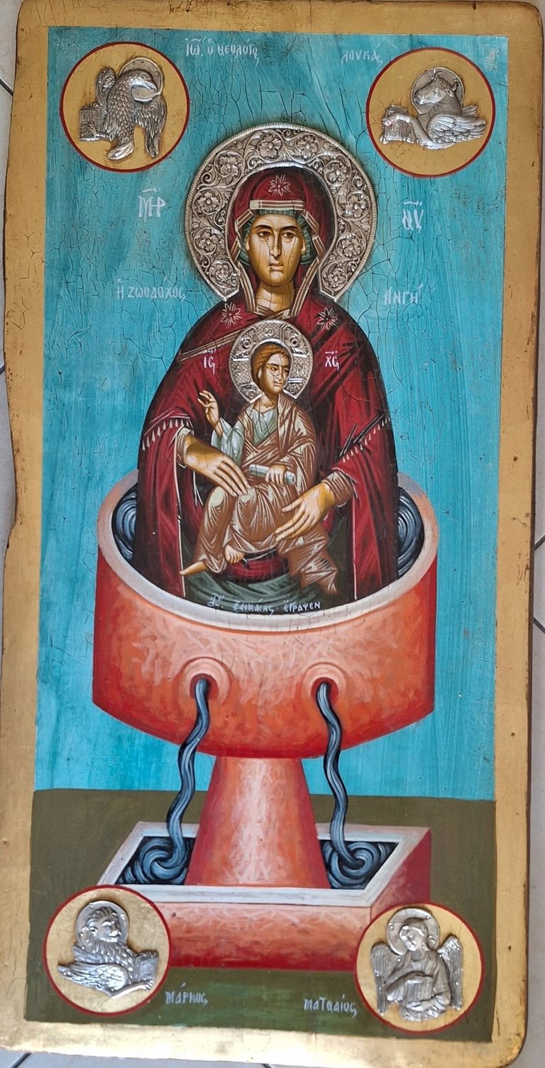 Orthodox icon depicting Virgin Mary and Christ Child in red robes, with ornate halo, positioned above a red chalice, surrounded by four medallions with saints, on turquoise background