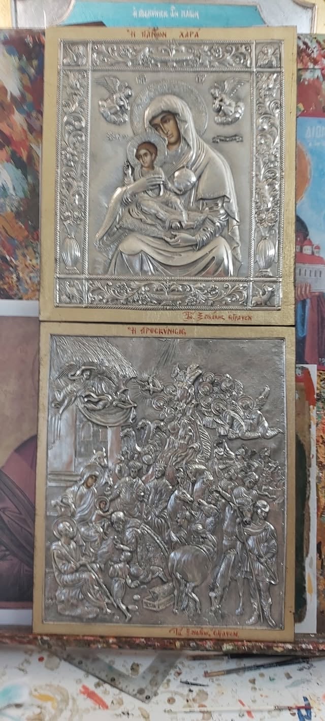 Two Eastern Orthodox silver religious icons in gold frames depicting Virgin Mary with Child above and a complex biblical scene below