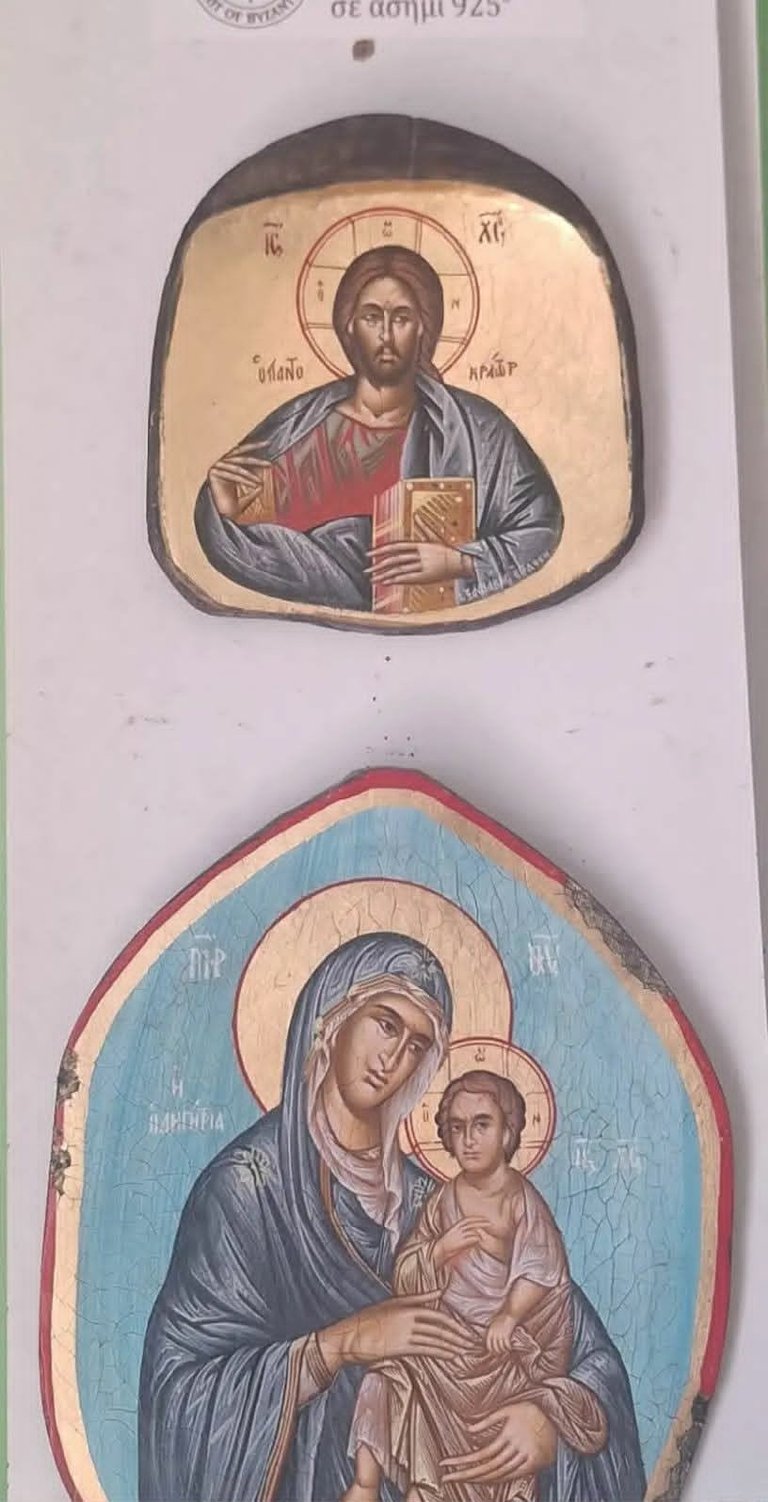 Two Eastern Orthodox religious icons: Christ Pantocrator holding a gospel book above, and the Virgin Mary with Child Jesus below, both with gold halos on aged wood panels