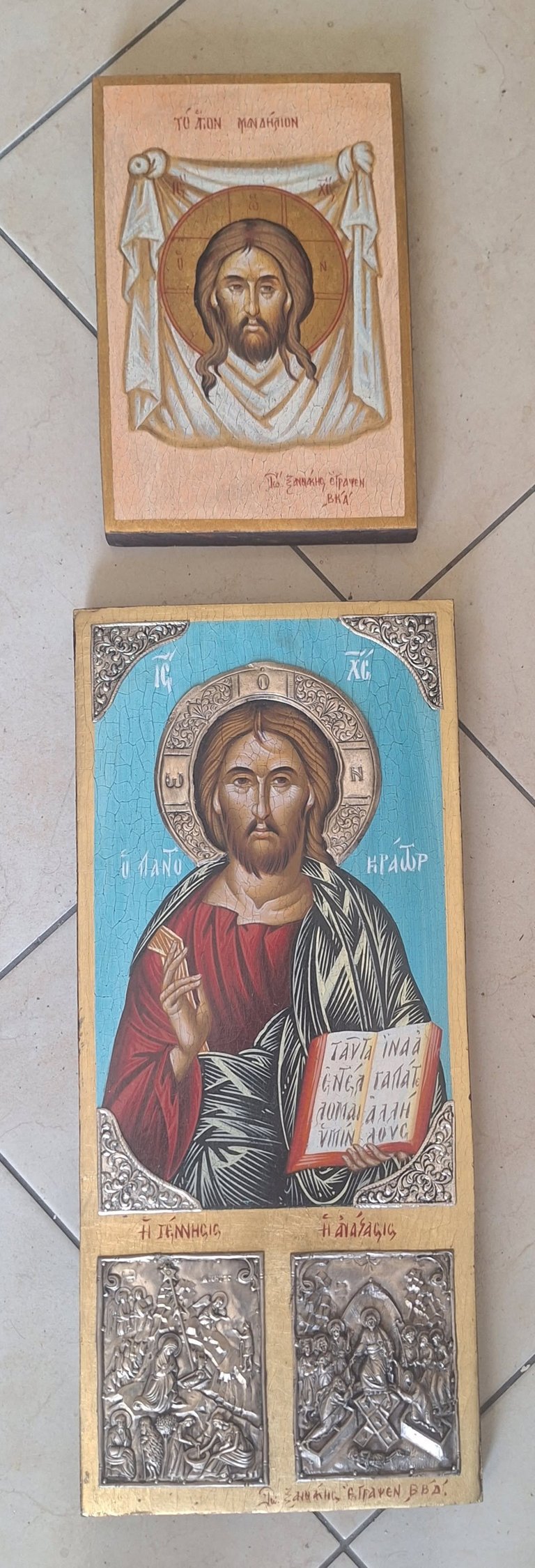 Two Orthodox Christian religious icons on a tiled surface featuring Christ depicted with a halo and formal religious imagery and text