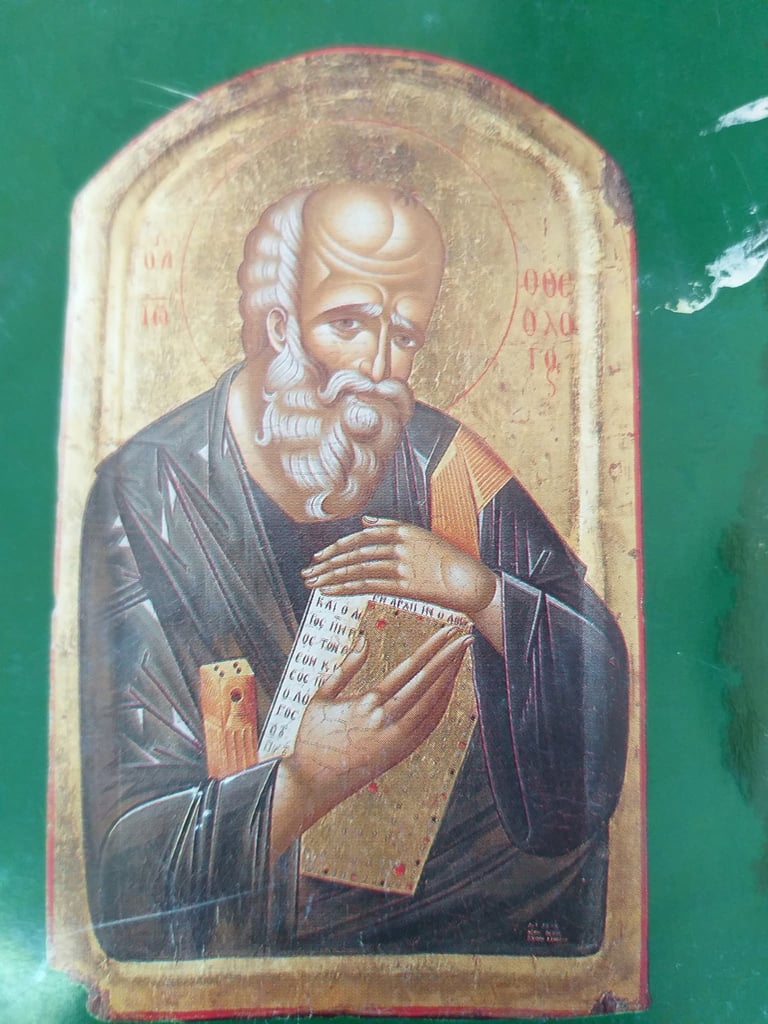 Eastern Orthodox religious icon depicting a bearded saint with gold halo holding a book, painted on wooden panel