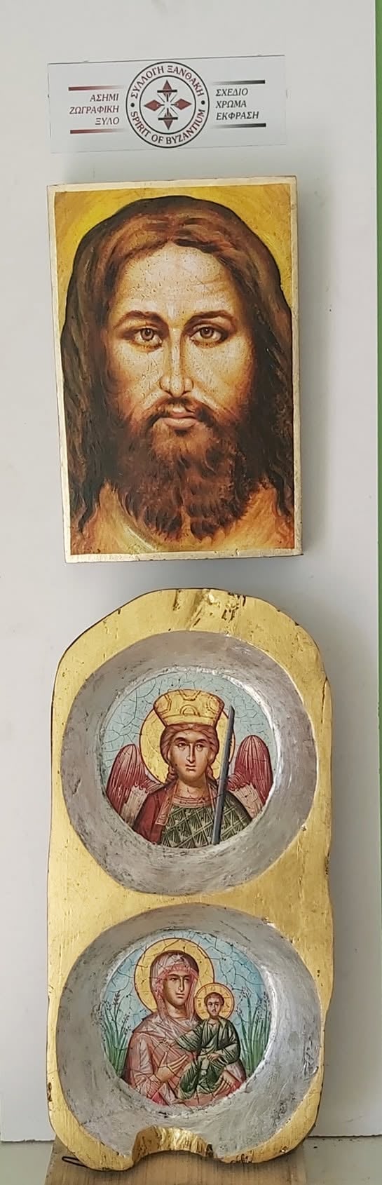 Byzantine religious icon display featuring portrait of bearded male figure above two circular medallions with haloed figures on gold background
