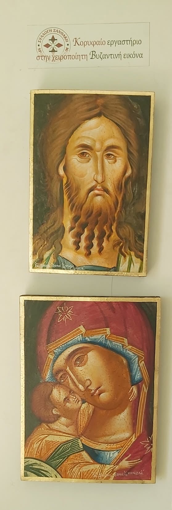 Two Byzantine religious icons displayed vertically: upper icon shows Christ Pantocrator with brown hair and beard; lower icon depicts Mary holding baby Jesus with gold halos and red background.