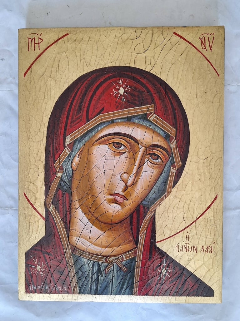 Byzantine-style religious icon of the Virgin Mary on gold leaf, wearing red veil and blue garment with small stars