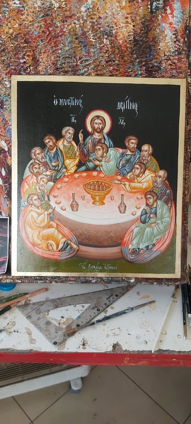 Orthodox religious icon depicting Jesus Christ with halo surrounded by twelve apostles at a communion table with bread and wine