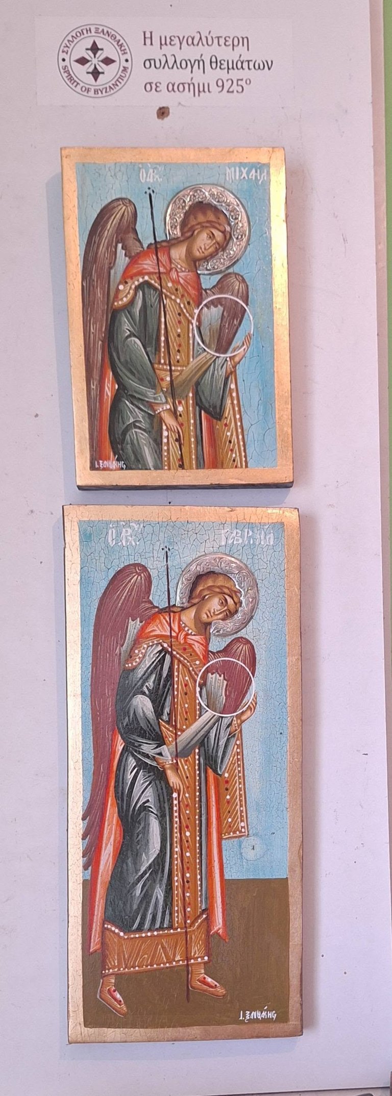 Two religious wooden icon panels depicting Byzantine saints with halos, wings, and traditional Orthodox iconographic style painted in gold leaf