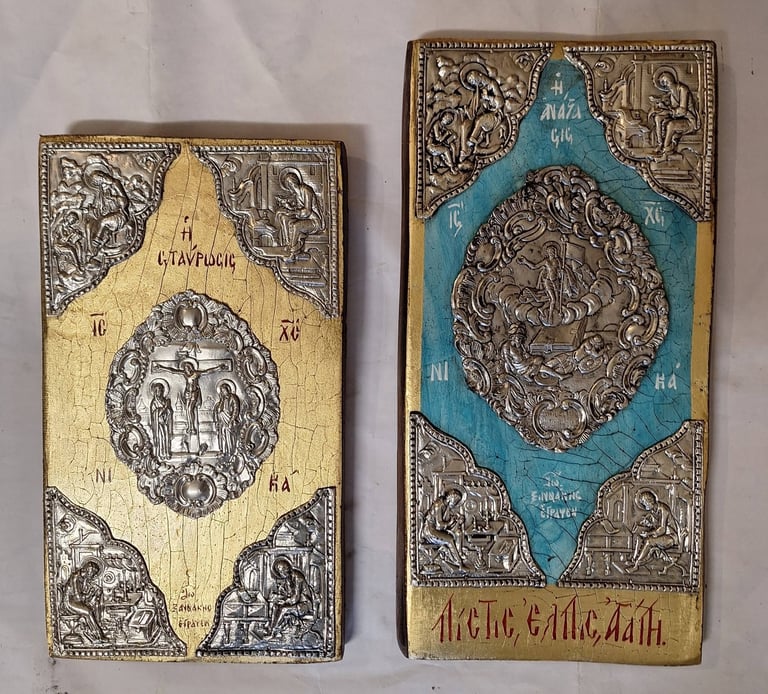 Two ornate Orthodox religious icon panels with metal filigree frames and embossed centers on cream and blue backgrounds