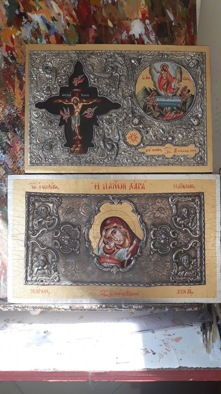 Two Orthodox religious icons with ornate silver backgrounds and colorful religious imagery, mounted on cream-colored backing panels.