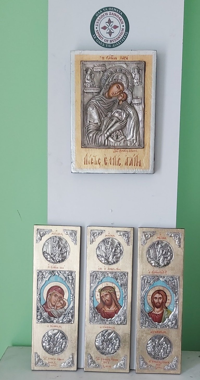 Collection of four Orthodox Christian religious icons mounted on a green wall, featuring silver metalwork borders and hand-painted portraits.