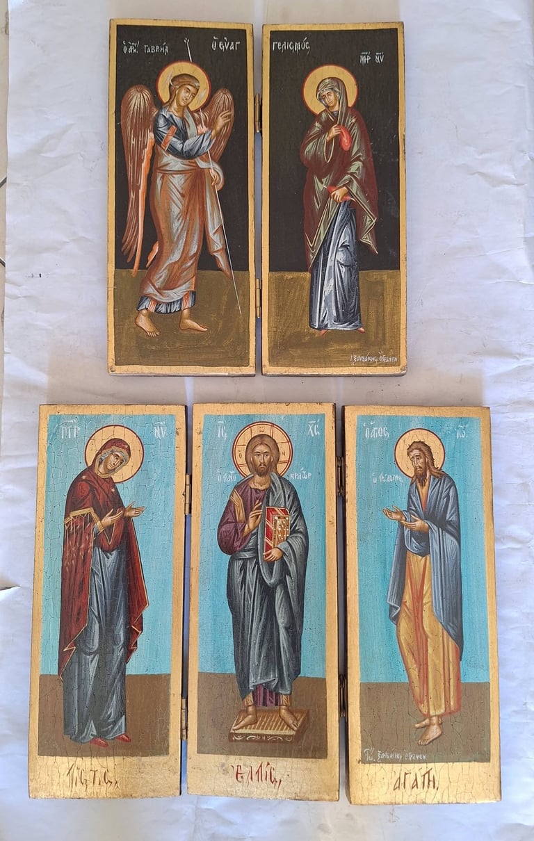 Collection of five Eastern Orthodox religious icon paintings depicting saints with halos on dark backgrounds, arranged on white fabric