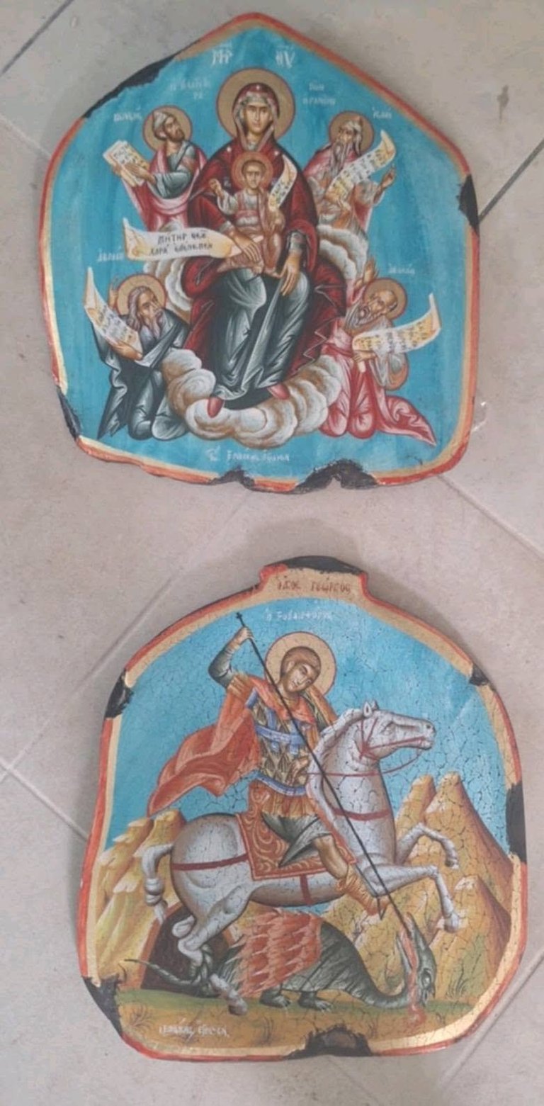 Two ornate religious icons with red borders: top shows Virgin Mary with Christ Child surrounded by angels on blue background; bottom depicts Saint George on horseback slaying a dragon