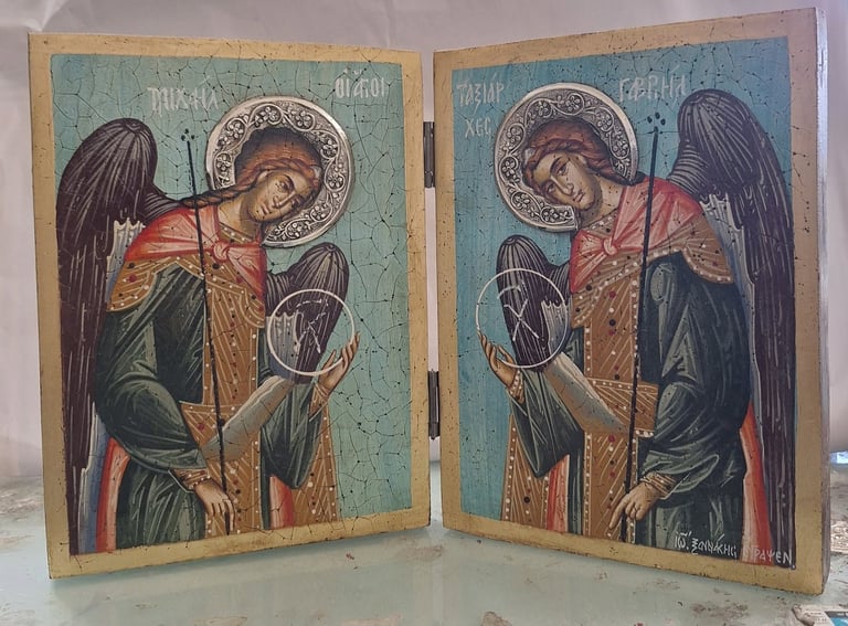 Diptych icon depicting two winged angels with halos wearing red and gold robes against turquoise backgrounds