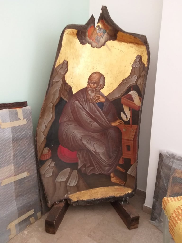 Orthodox icon painting on wood depicting a robed religious figure with angels, displayed on a stand