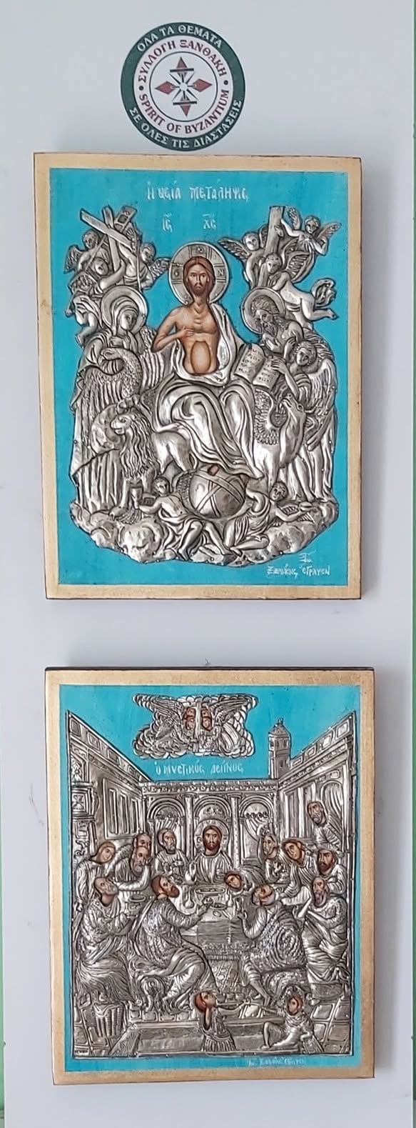 Two Byzantine religious icons with turquoise backgrounds and ornate silver metalwork designs, mounted on tan boards beneath an official seal emblem.