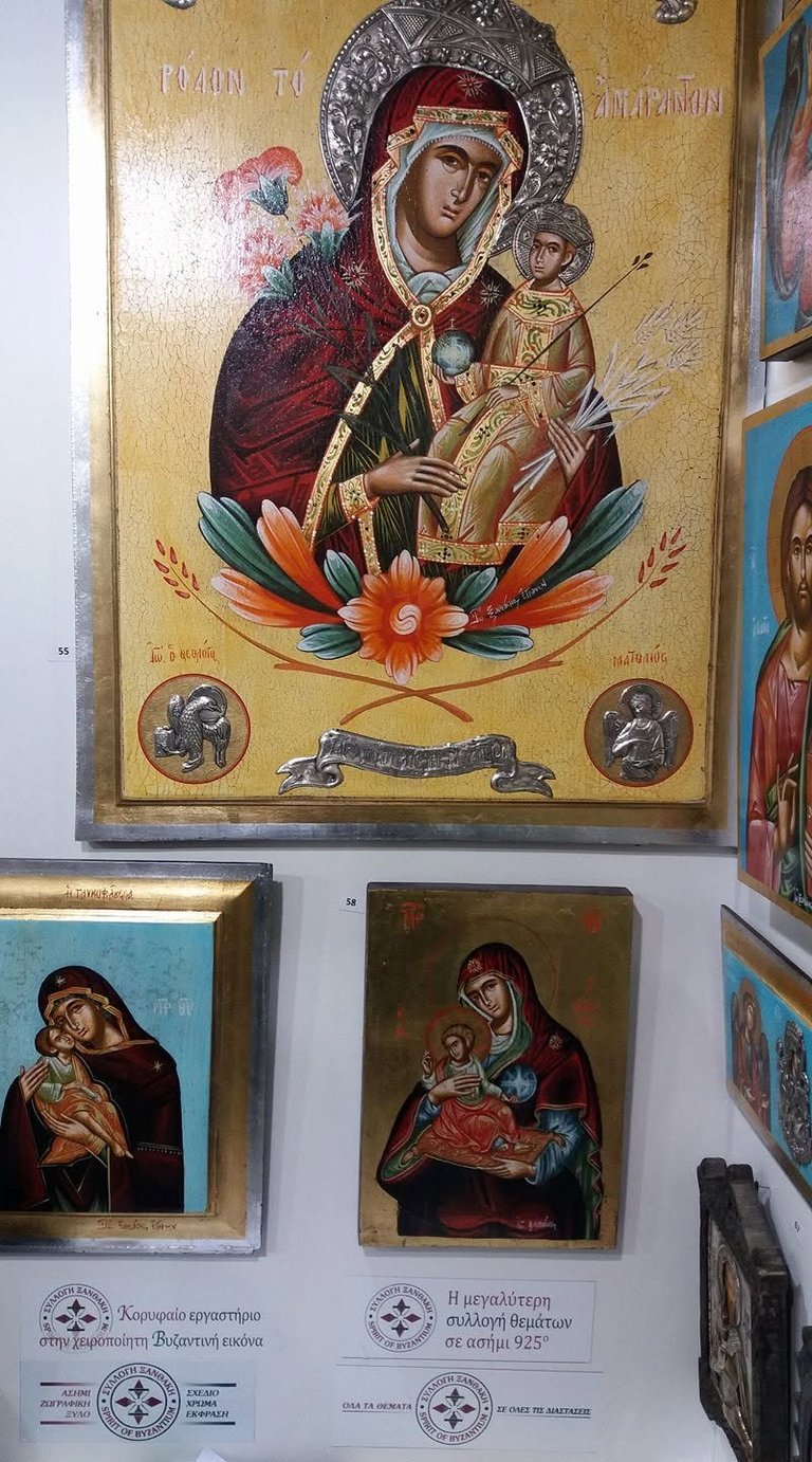 Religious icon gallery display showing Byzantine-style paintings of the Virgin Mary and Child Jesus with ornate golden halos and decorative floral motifs