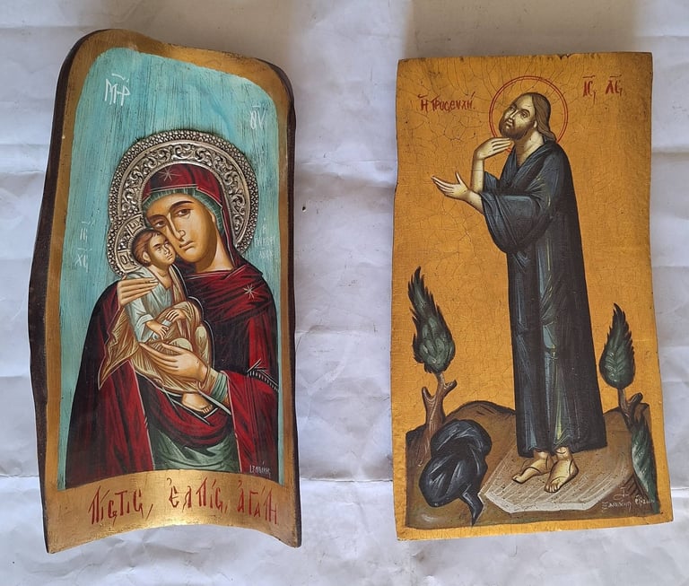 Two ancient religious icons on wooden panels depicting Orthodox Christian saints with gold halos and traditional iconographic style