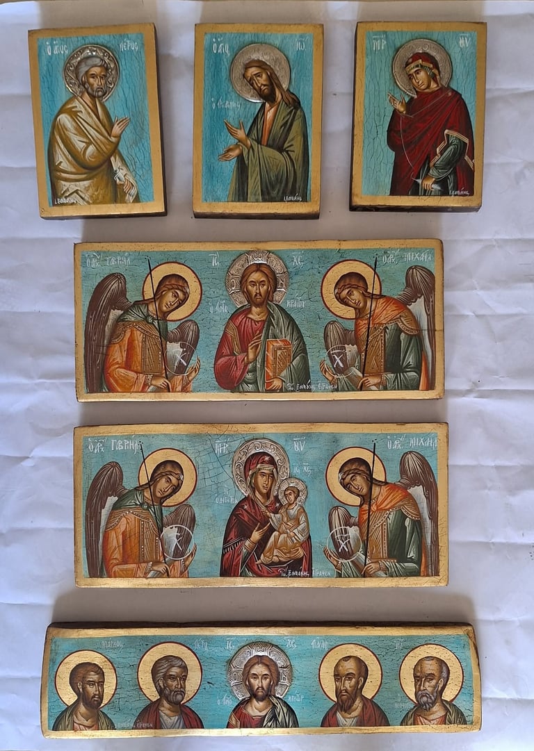 Collection of Orthodox religious icons displayed on white background, featuring painted wooden panels with religious figures and saints with halos