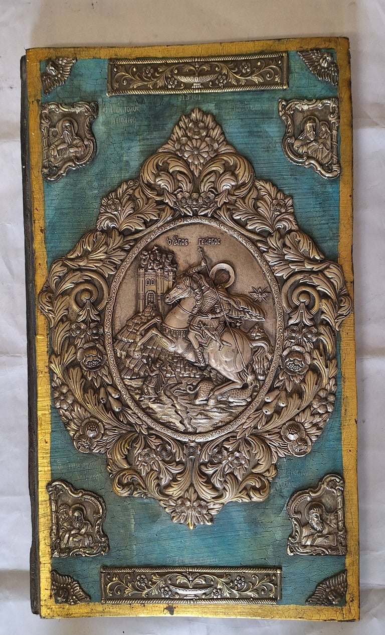 Ornate antique book cover with turquoise leather and embossed bronze medallion featuring a figure on horseback
