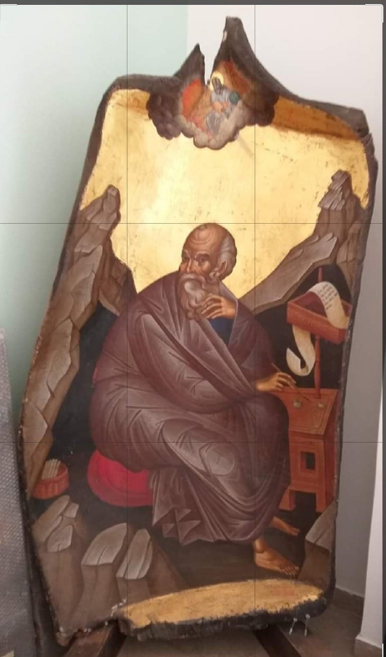 Orthodox religious icon depicting a bearded saint in burgundy robes with angels above, painted on aged wooden panel with gold background