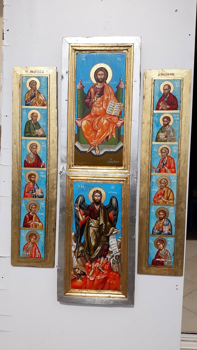 Three religious icon panels displayed on a white wall, featuring Jesus Christ centrally with angels and saints in traditional Byzantine style with gold frames.