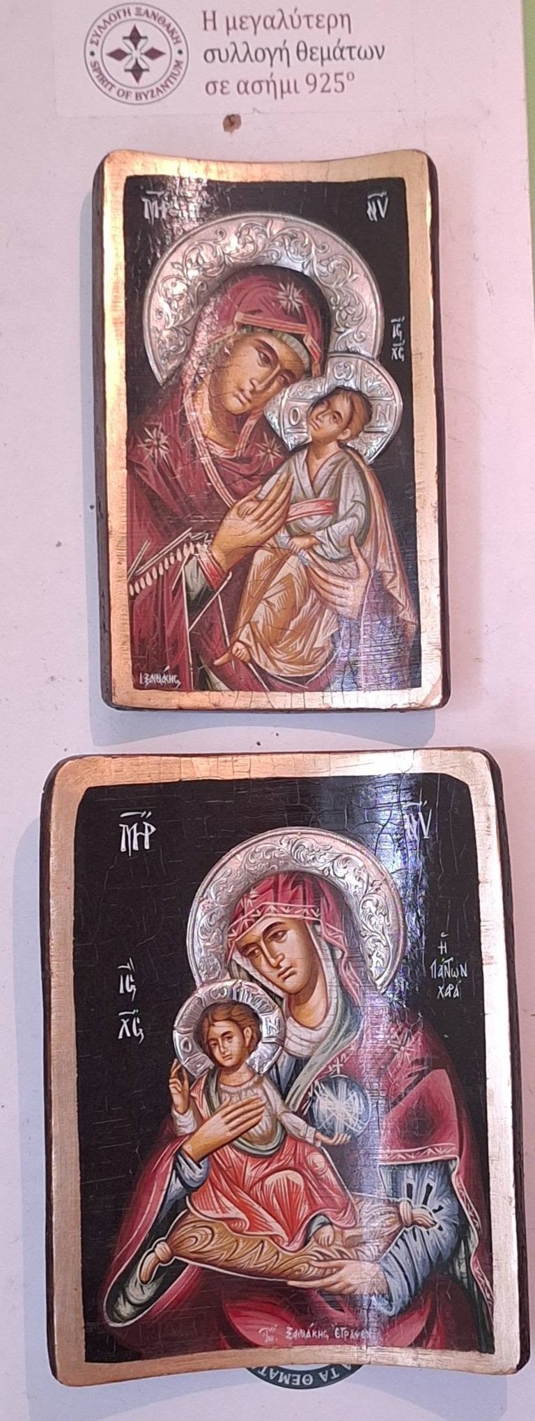 Two Orthodox religious icon plaques with 925 silver depicting Mary holding Jesus, with ornate halos and Greek text