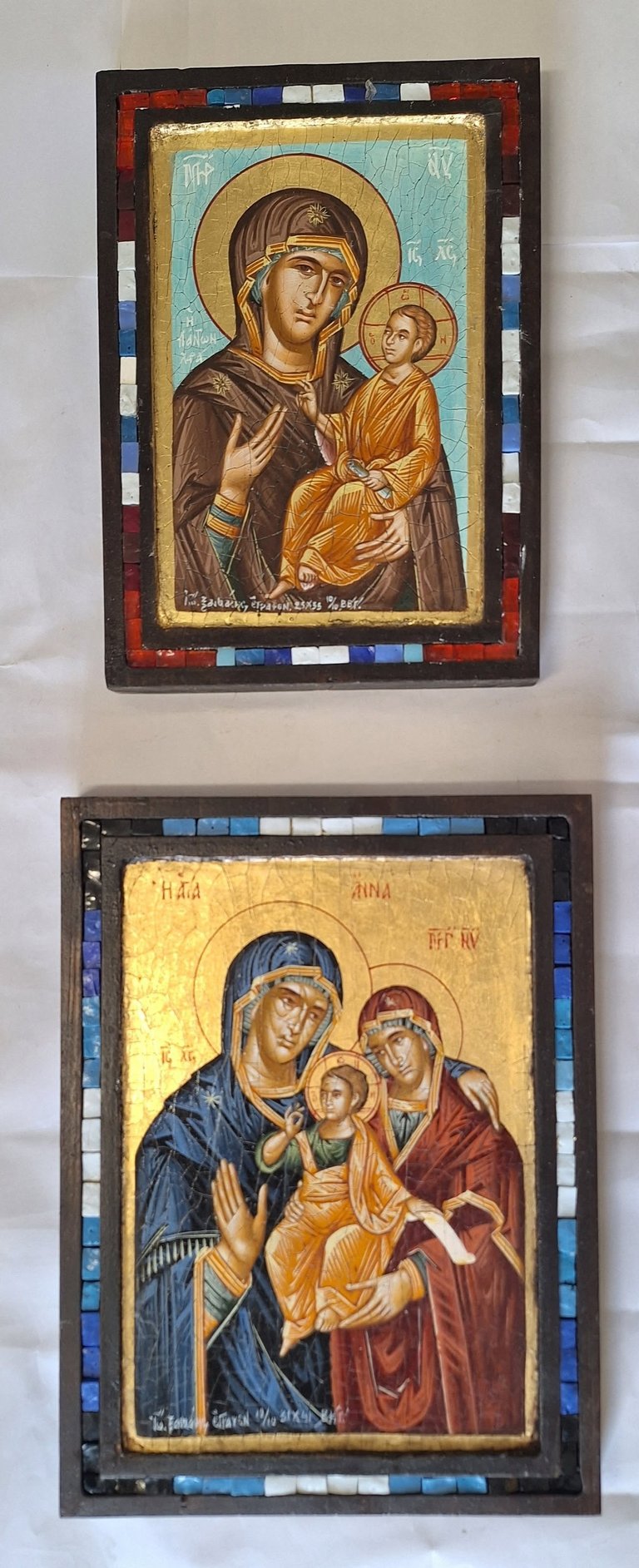 Two religious Orthodox icons depicting the Virgin Mary holding the Christ Child, with gold leaf backgrounds and decorative mosaic borders