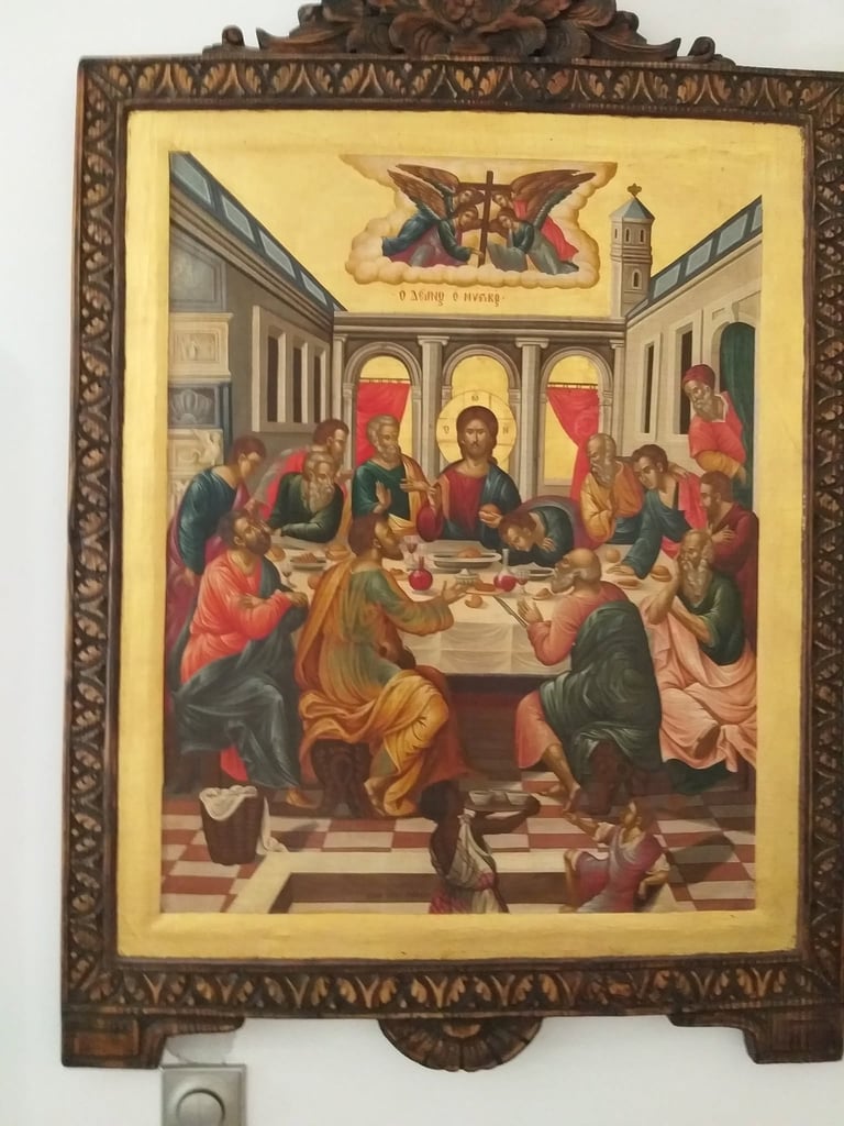 Orthodox religious icon depicting Jesus Christ at a table with apostles in an ornate carved wooden frame with gold detailing