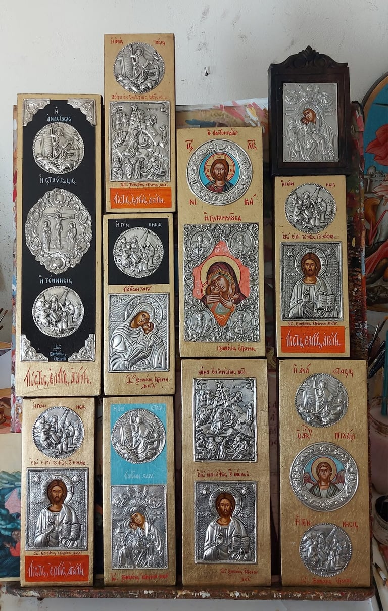Collection of Orthodox religious icon panels and strips arranged vertically, featuring silver-embossed portraits and biblical scenes with Cyrillic text on wooden backgrounds.