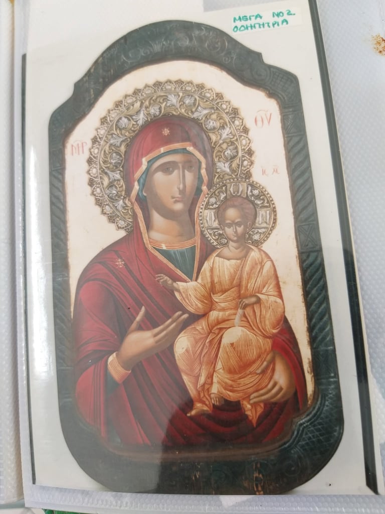 Orthodox religious icon depicting Virgin Mary in red robes holding Christ child, with ornate gold halo on dark wooden panel
