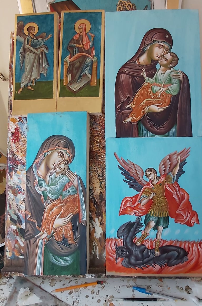 Collection of religious icon paintings on blue canvas depicting Madonna with child and saints in traditional Orthodox style