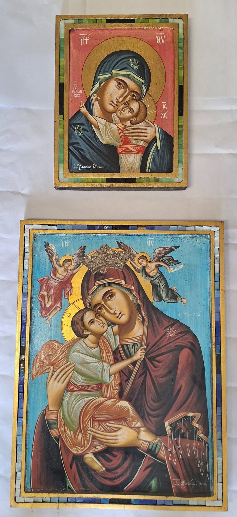 Two religious Eastern Orthodox icons depicting the Virgin Mary holding the Christ Child, with gold halos and decorative borders
