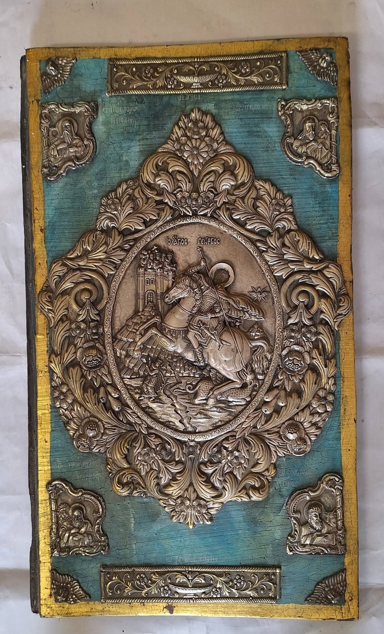 Ornate antique book cover with turquoise leather and embossed metal relief depicting a mounted knight in decorative baroque frame